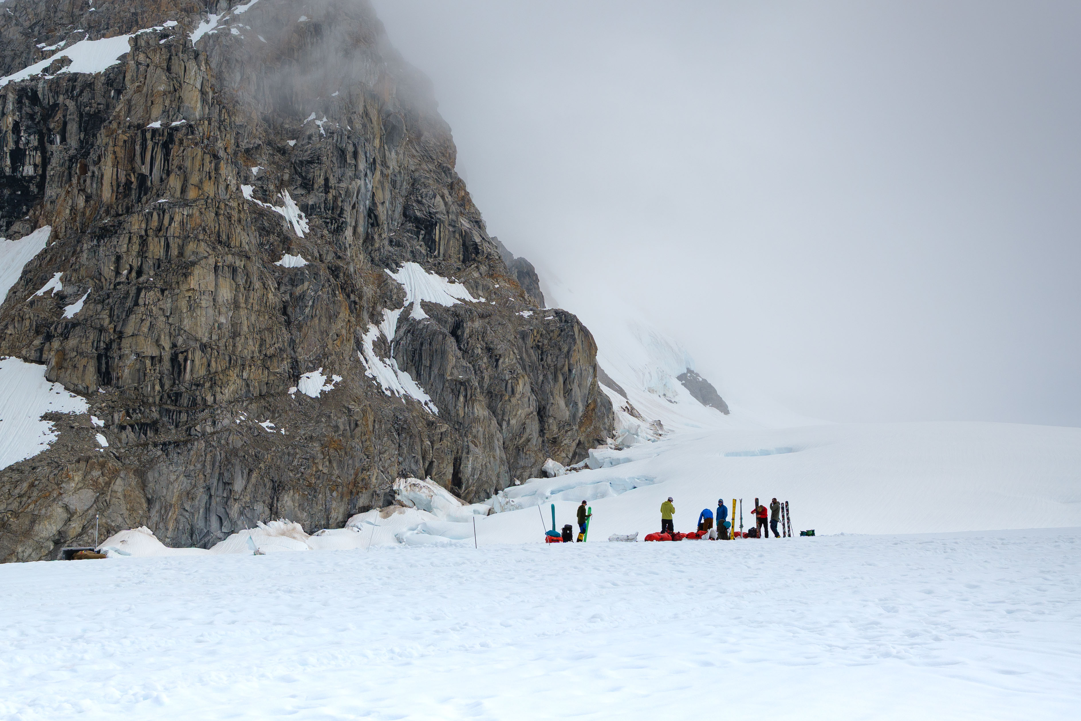 Climbers at Denali base camp on the Kahiltna Glacier with Mt. Hunter rising behind