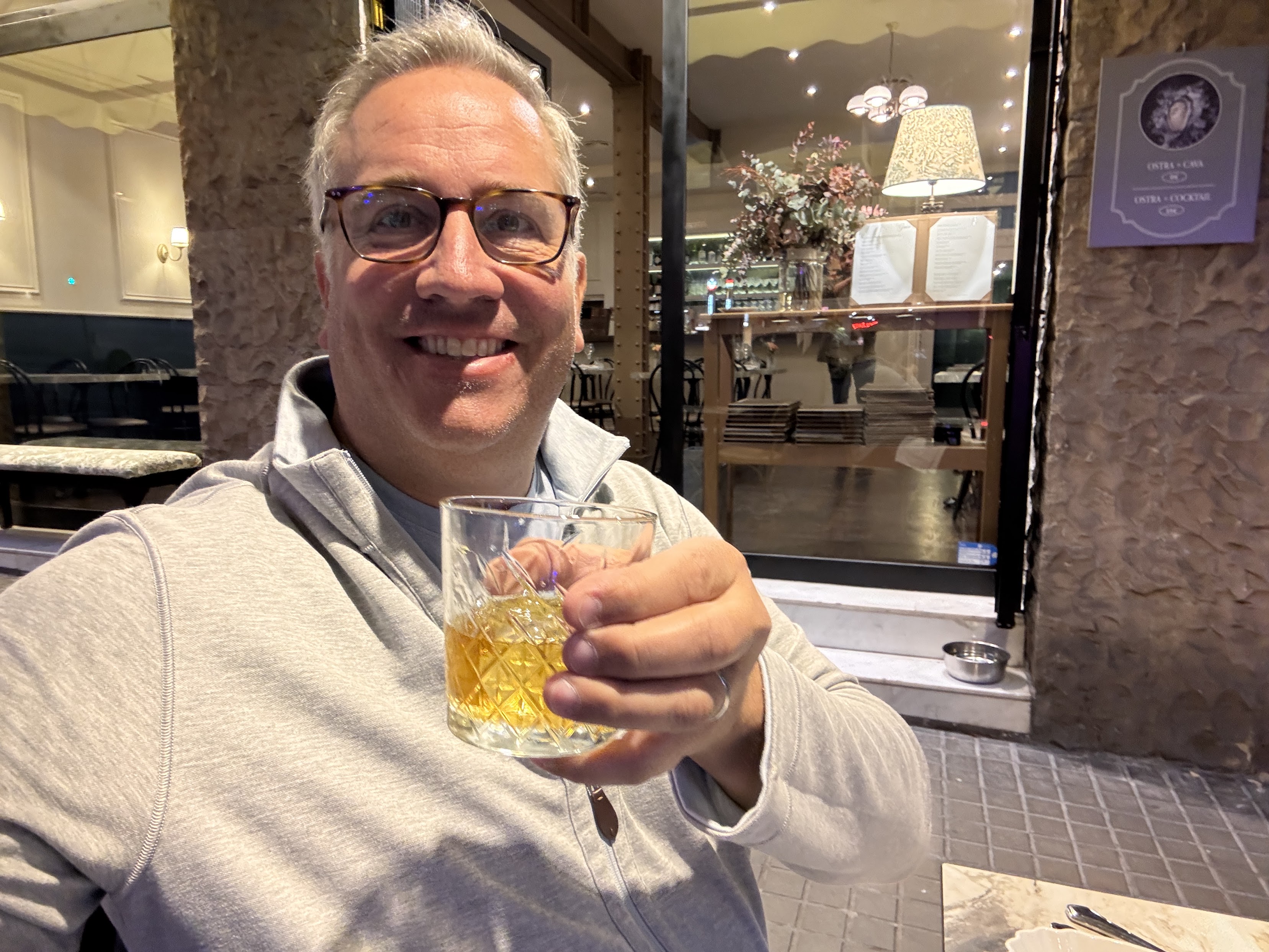 Cocktail glass raised at a Barcelona restaurant terrace at night
