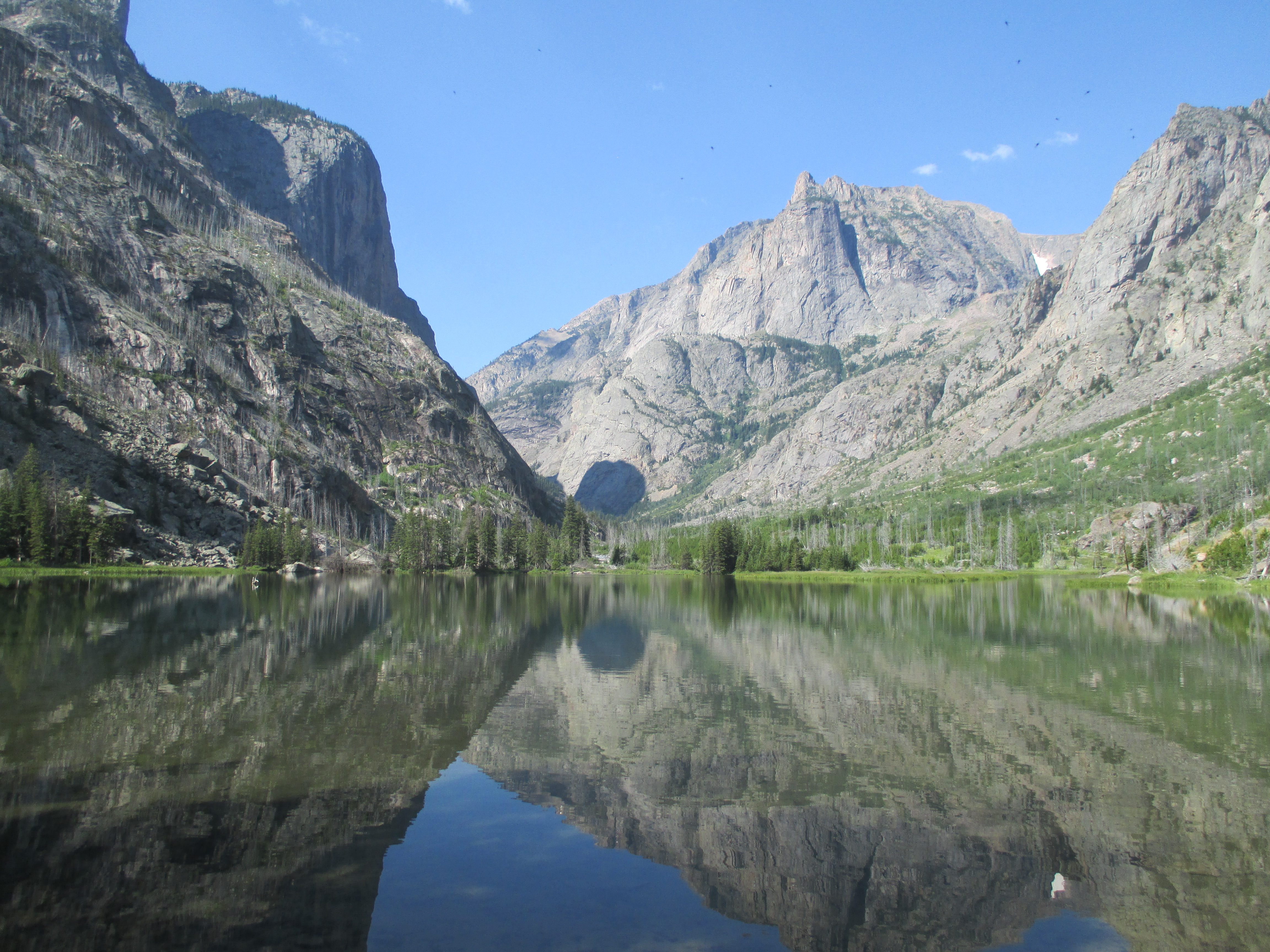 Granite peaks reflected perfectly in the still surface of an East Rosebud lake on a clear morning
