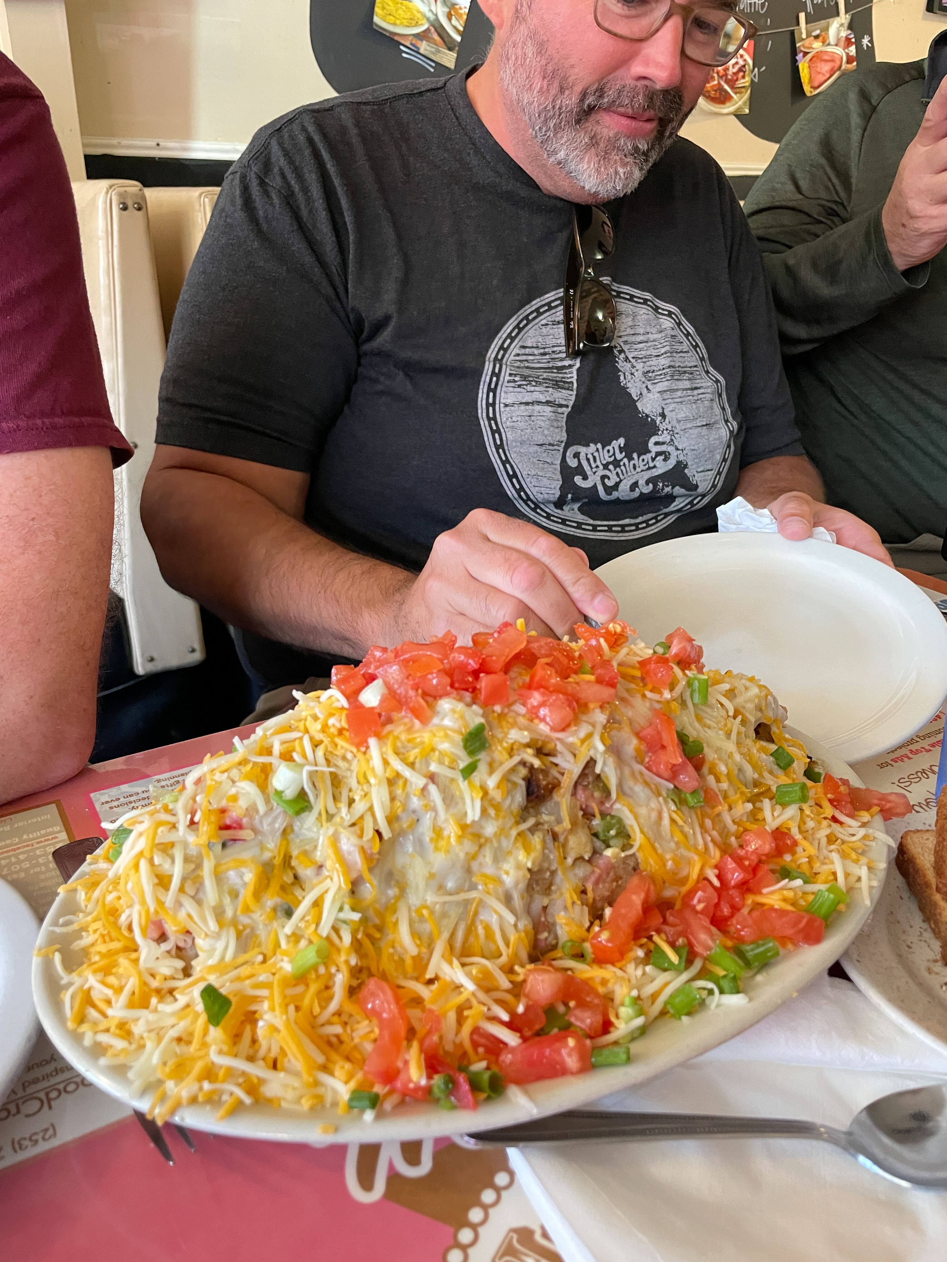 A hiker confronts an enormous breakfast burrito piled high with cheese, tomatoes, and green onions at Marcia's Silver Spoon Cafe in Packwood