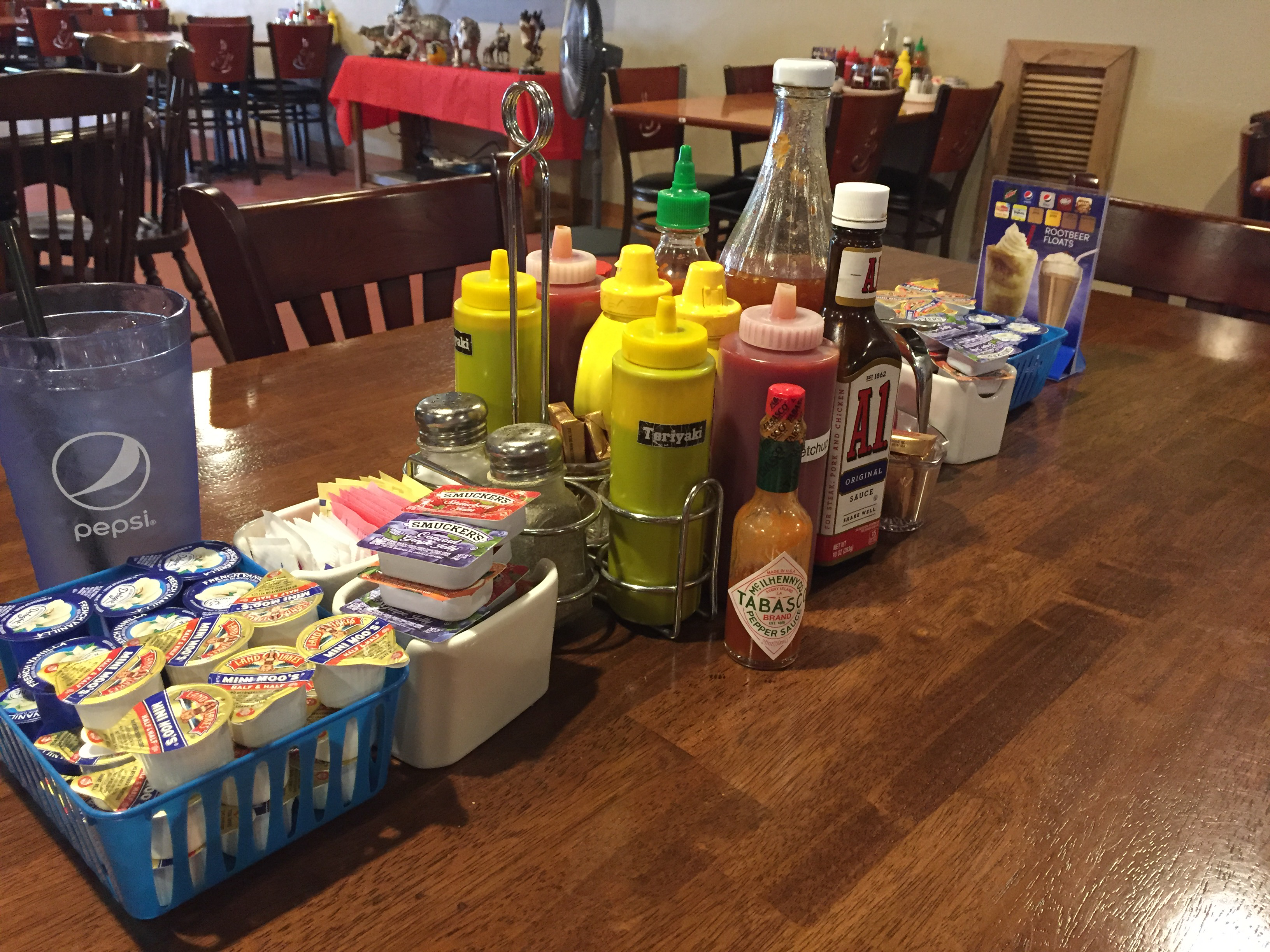 A diner table loaded with an improbable variety of condiment bottles, squeeze containers, and sauce caddies at the Mondo Restaurant in Marblemount