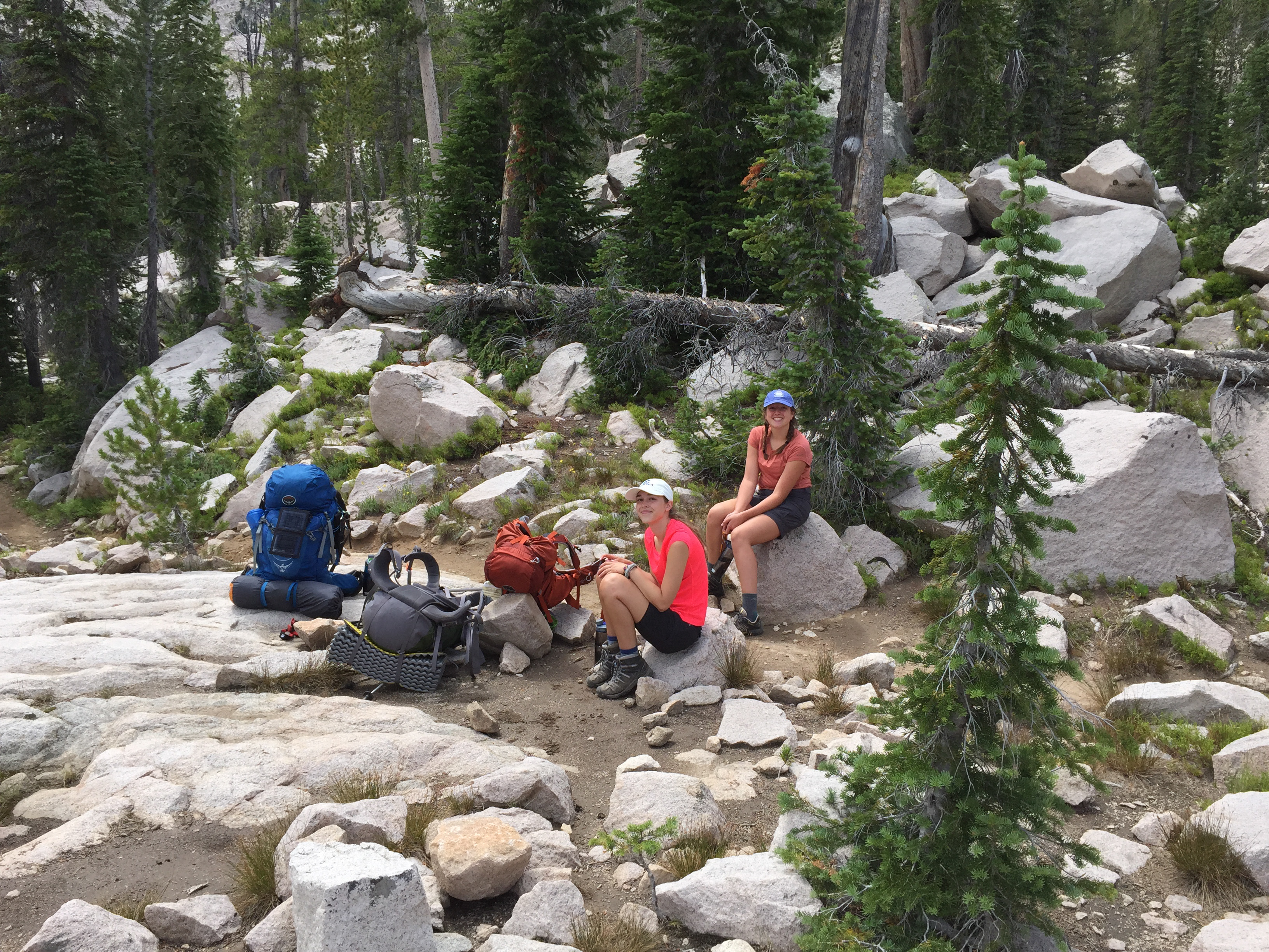 Two hikers resting on granite boulders in the Sawtooth backcountry